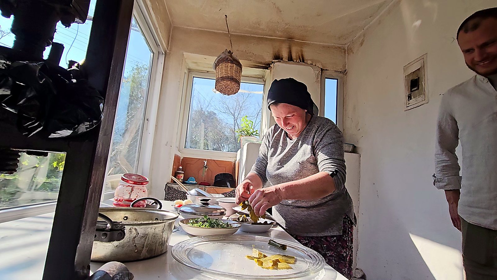 Host wrapping stuffed grape leaves (dolma) by hand in the kitchen