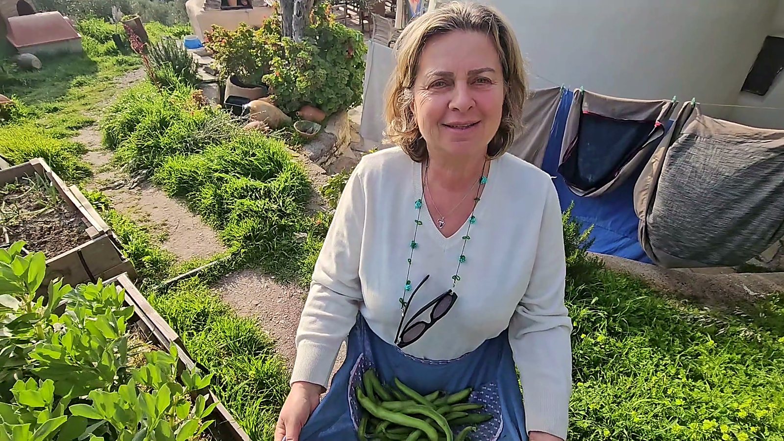 Host holding freshly picked green beans from the permaculture garden